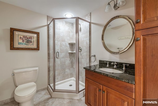 bathroom featuring toilet, vanity, tile patterned flooring, and a shower with shower door