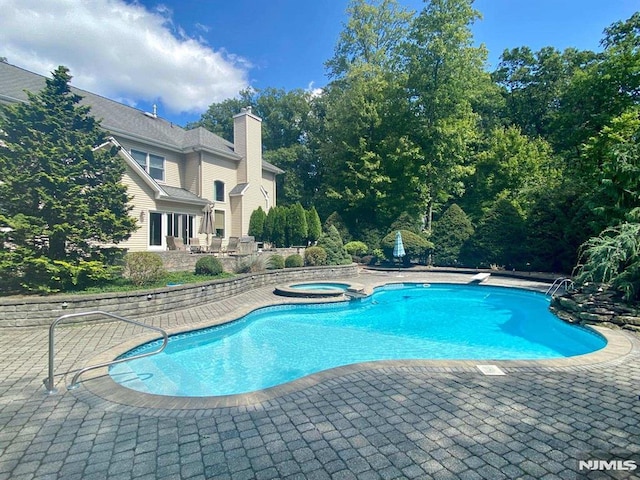 view of swimming pool with an in ground hot tub and a patio area