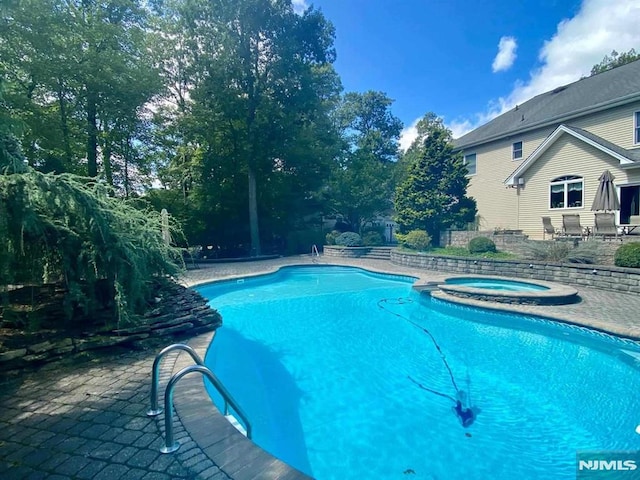 view of pool featuring a patio area and an in ground hot tub