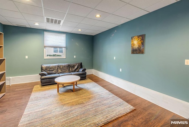 living room featuring hardwood / wood-style flooring and a drop ceiling