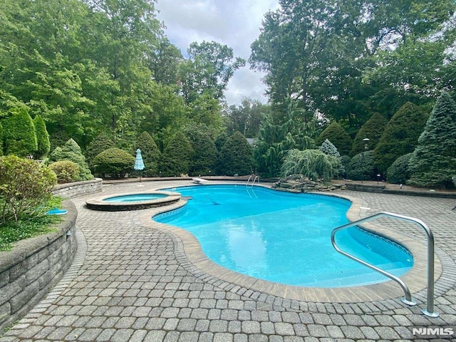 view of pool featuring an in ground hot tub