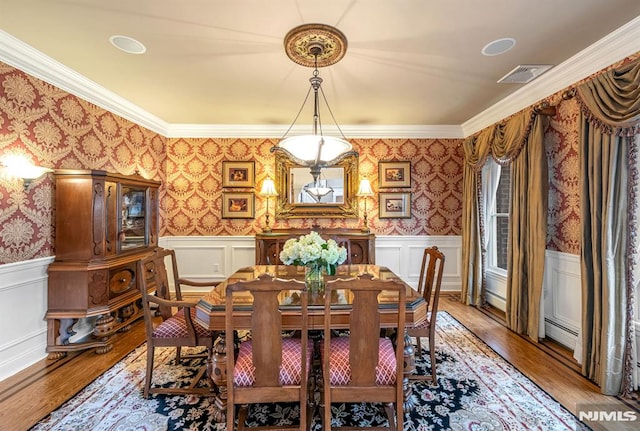 dining room with ornamental molding and light wood-type flooring