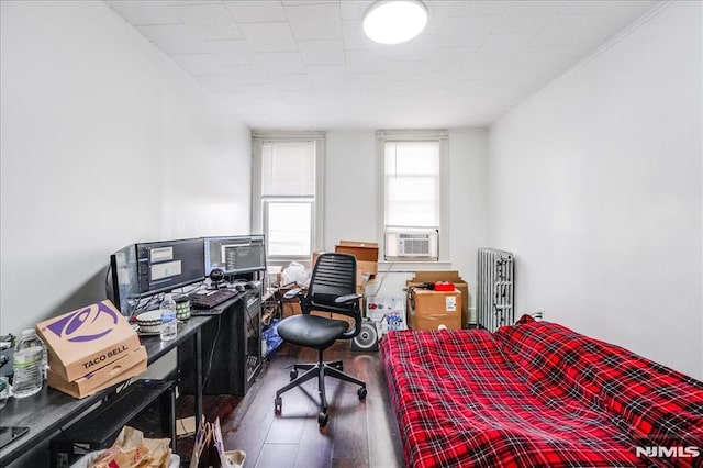 bedroom featuring radiator, cooling unit, and wood-type flooring