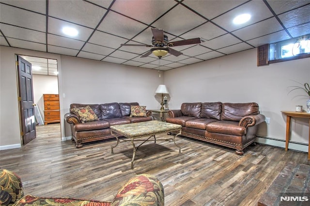 living room featuring a paneled ceiling, dark hardwood / wood-style flooring, a baseboard heating unit, and ceiling fan