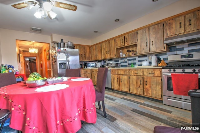 kitchen featuring tasteful backsplash, stainless steel appliances, dark hardwood / wood-style floors, and ceiling fan