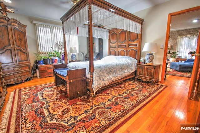 bedroom featuring light hardwood / wood-style flooring and multiple windows