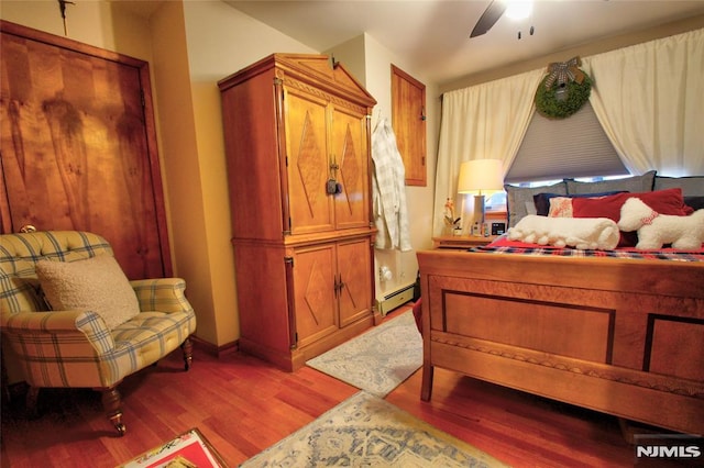 bedroom with a baseboard radiator, ceiling fan, and light hardwood / wood-style flooring