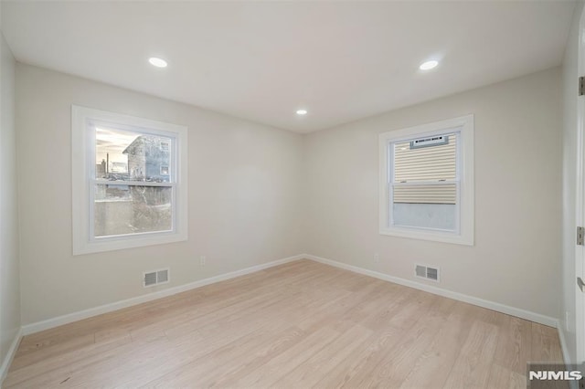 spare room with a healthy amount of sunlight and light hardwood / wood-style floors