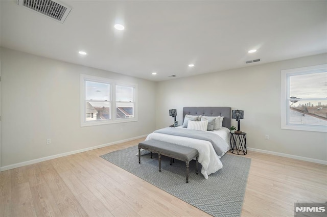 bedroom featuring multiple windows and light hardwood / wood-style flooring