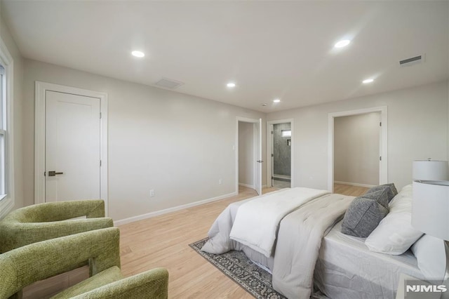 bedroom featuring ensuite bath and light wood-type flooring