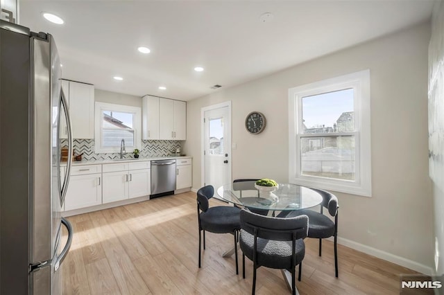 dining space featuring sink and light hardwood / wood-style floors