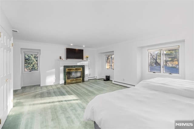 carpeted bedroom with baseboard heating, crown molding, and a fireplace