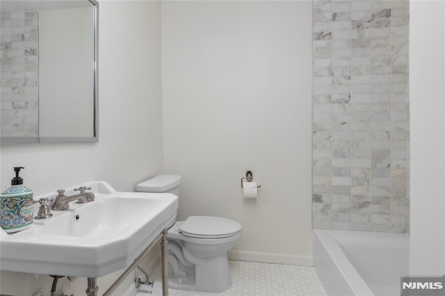 bathroom featuring sink, a tub, and toilet