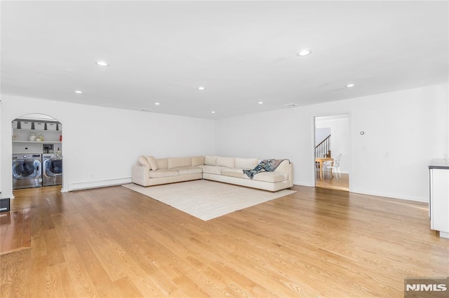 unfurnished living room with light wood-type flooring and washing machine and clothes dryer