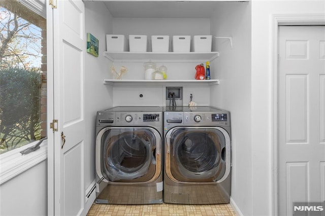 clothes washing area with a baseboard heating unit and separate washer and dryer