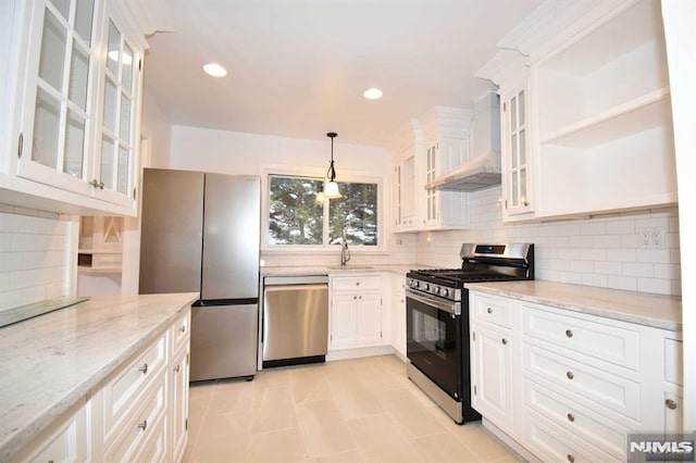 kitchen featuring decorative light fixtures, premium range hood, appliances with stainless steel finishes, and white cabinetry