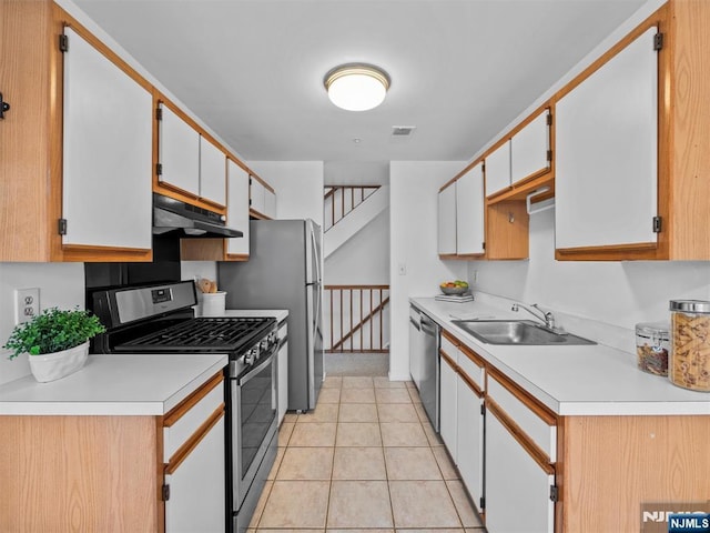 kitchen featuring light tile patterned floors, appliances with stainless steel finishes, sink, and white cabinets