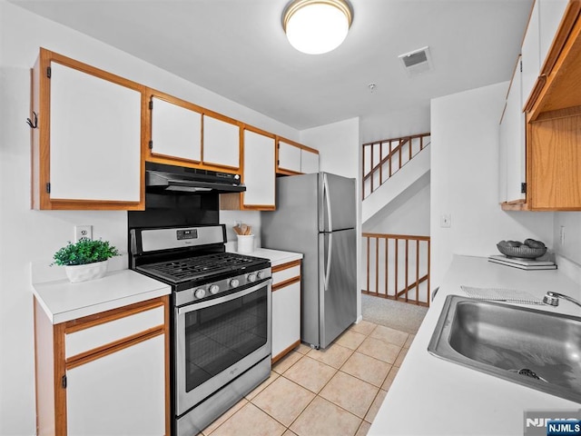 kitchen featuring white cabinetry, appliances with stainless steel finishes, light tile patterned flooring, and sink