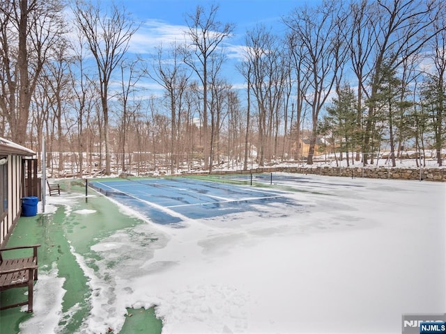 yard layered in snow with tennis court