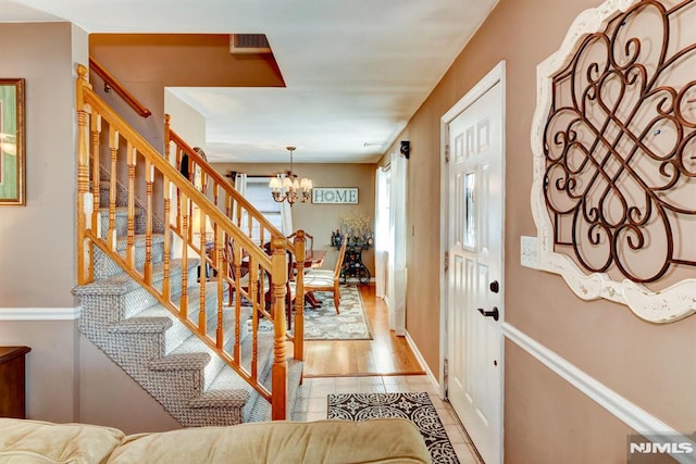 entryway featuring a notable chandelier and light tile patterned floors