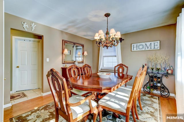 dining space with light wood-type flooring and a chandelier