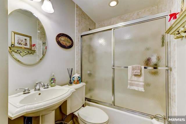 full bathroom featuring shower / bath combination with glass door, toilet, and sink