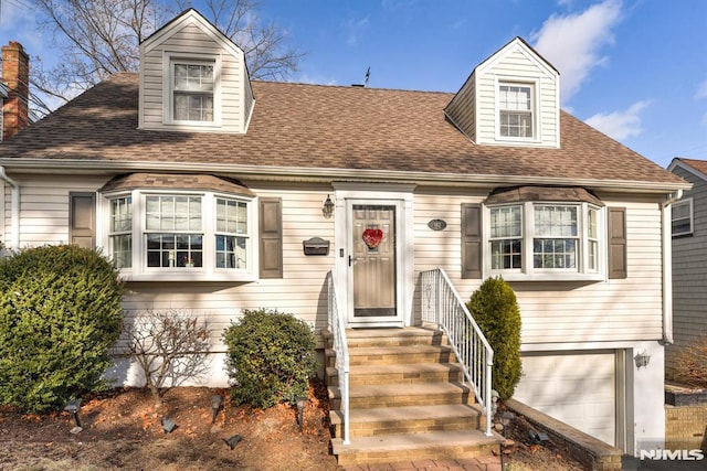 new england style home featuring a garage