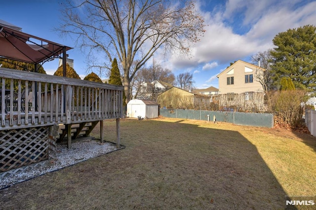 view of yard featuring a gazebo, a storage shed, and a wooden deck