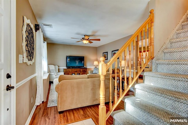 living room featuring wood-type flooring and ceiling fan