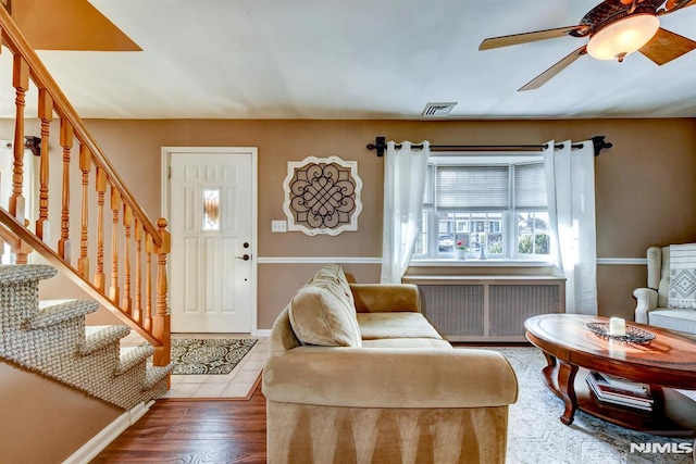 living room with dark hardwood / wood-style flooring, radiator heating unit, and ceiling fan