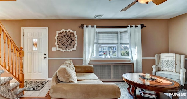 interior space with tile patterned flooring, ceiling fan, and radiator heating unit