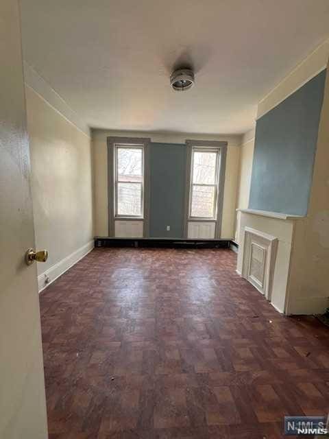 unfurnished room featuring crown molding and dark parquet floors