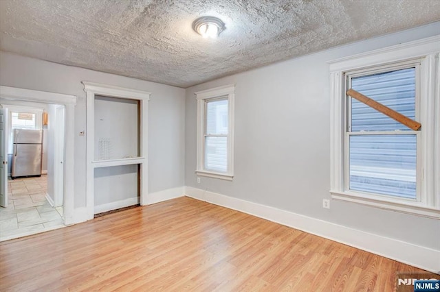 empty room featuring light hardwood / wood-style floors and a textured ceiling