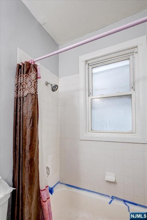 bathroom with toilet and shower / tub combo with curtain