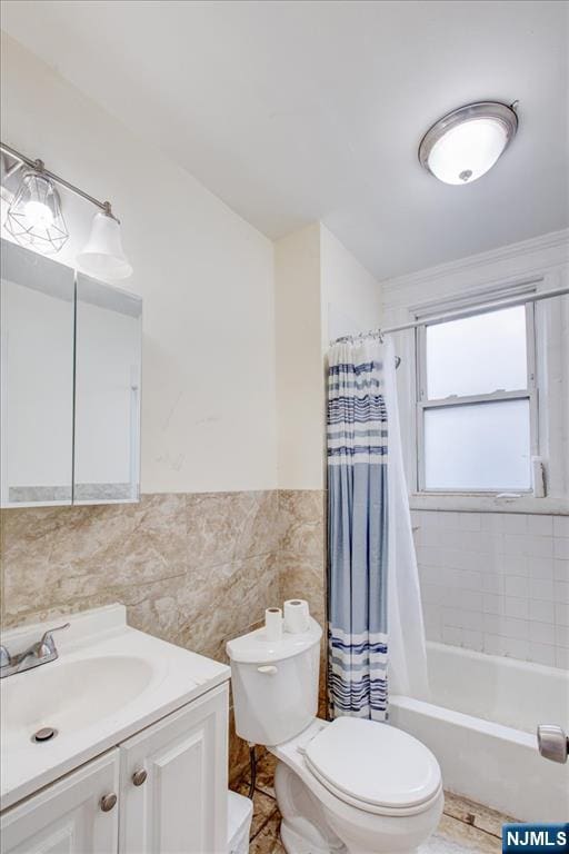 full bathroom with shower / bath combo, toilet, tile walls, and vanity