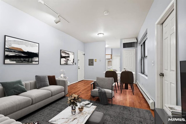 living room with dark hardwood / wood-style flooring, track lighting, and a baseboard radiator