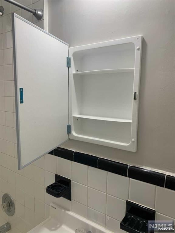 bathroom featuring tiled shower / bath and tasteful backsplash