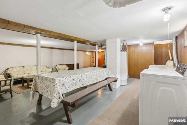 bedroom with washing machine and dryer, wooden walls, and gas water heater