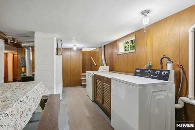 washroom with washer / dryer and wood walls