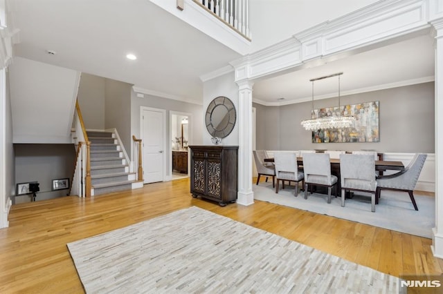 living room featuring crown molding, stairway, decorative columns, recessed lighting, and wood finished floors