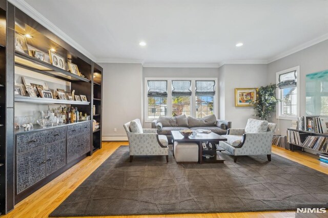 living room featuring recessed lighting, a baseboard heating unit, wood finished floors, and ornamental molding