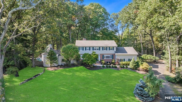 view of front of property with a chimney, a front lawn, and fence