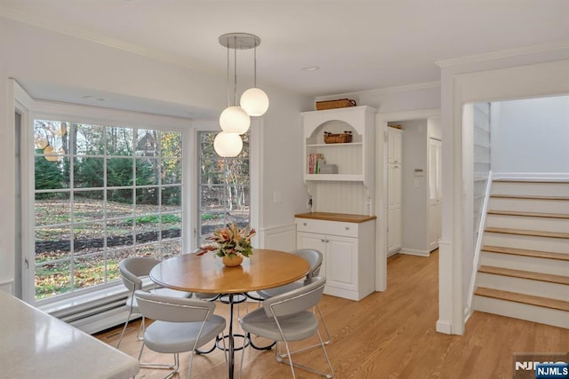 dining area featuring crown molding, stairway, light wood finished floors, and a baseboard radiator