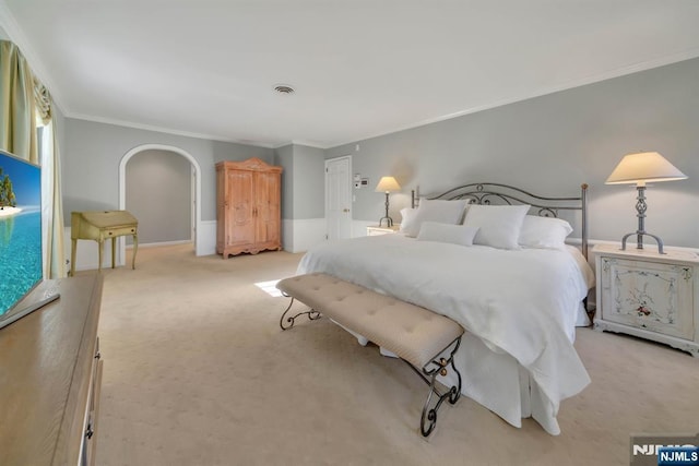 bedroom featuring visible vents, crown molding, light colored carpet, and arched walkways