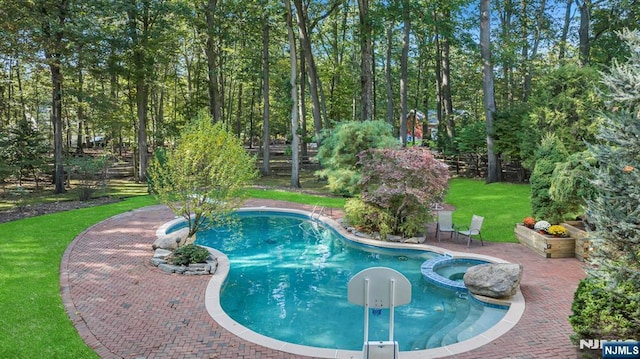 view of pool featuring a yard, a patio area, and a pool with connected hot tub