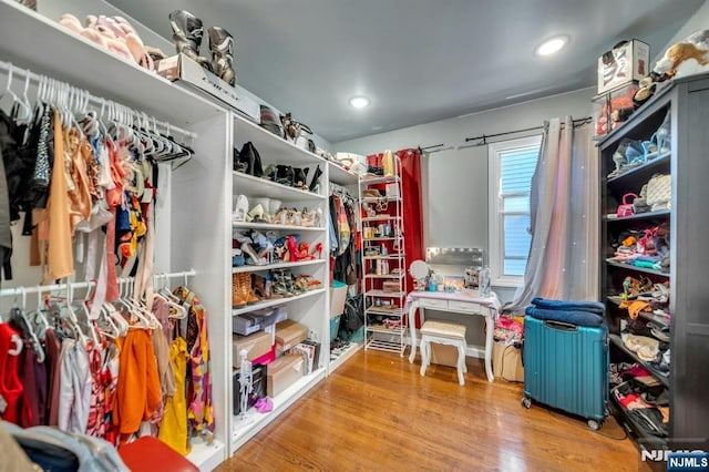 spacious closet featuring radiator heating unit and hardwood / wood-style floors