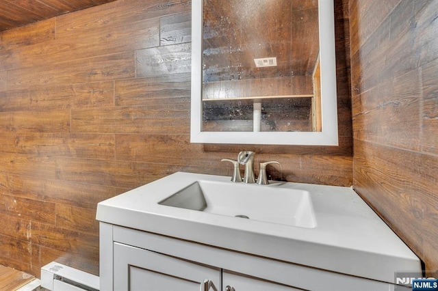 bathroom with vanity and wooden walls