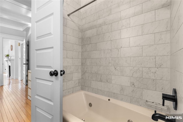 bathroom featuring tiled shower / bath combo and wood-type flooring