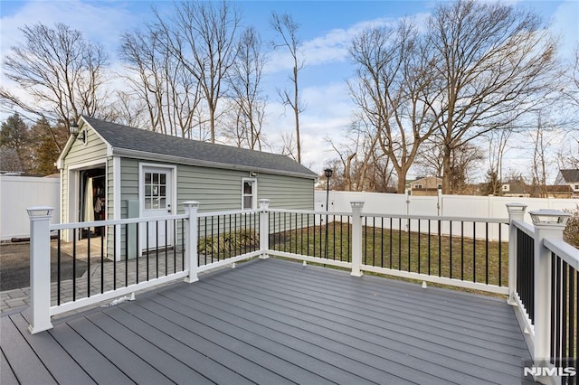 deck featuring a lawn and an outdoor structure