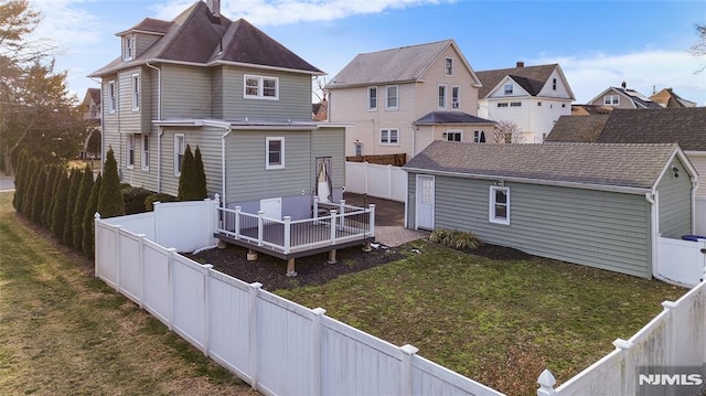 rear view of house with a wooden deck and a lawn